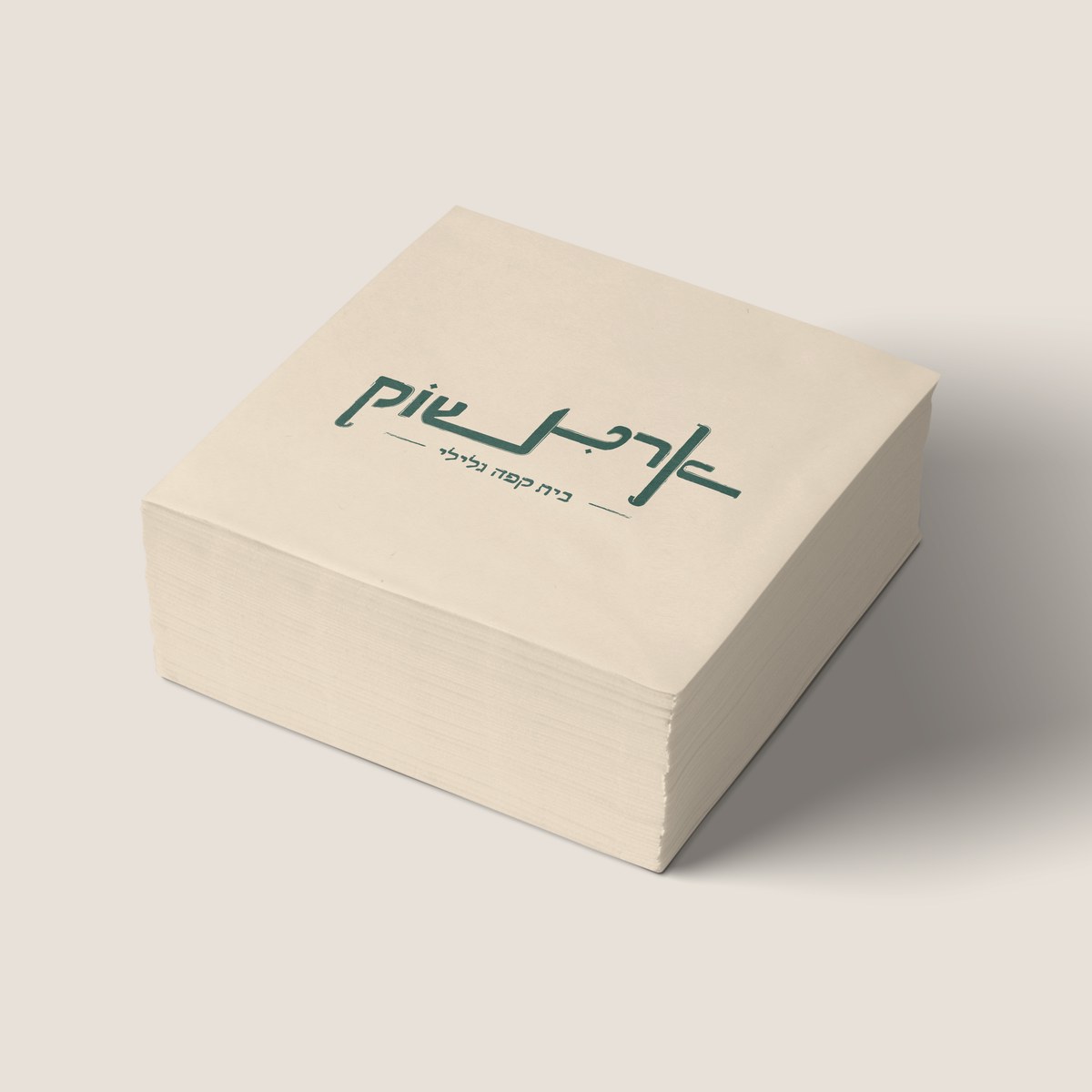 A stack of cream paper napkins printed with the green Artichoke wordmark